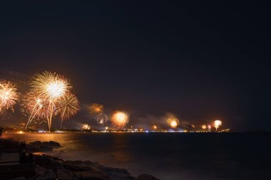 Kıyı boyunca havai fişekler, gece gökyüzünde deniz...