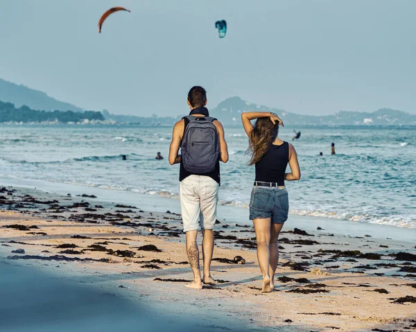 Молодая Пара Прогуливается Песчаному Пляжу Закате Летом Кайт Сёрферы Едут — стоковое фото