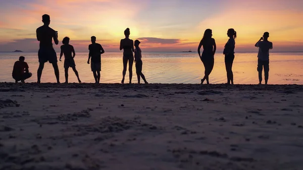 Silhuetas Pessoas Praia Areia Apreciando Pôr Sol Tirando Fotos Smartphones — Fotografia de Stock