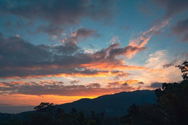 Renkli günbatımında dağları olan bir orman vadisi manzarası. Balkondan bak..