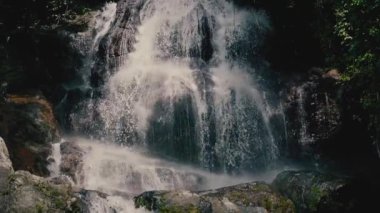 Güneşli bir günde, tropikal bir adada, ormandaki şelaleyi kapat.