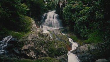 Güneşli bir günde, tropikal bir adada, ormandaki şelaleyi kapat.