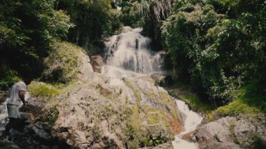 Güneşli bir günde, tropikal bir adada, ormandaki şelaleyi kapat.
