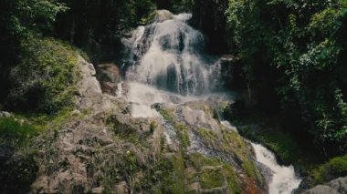 Güneşli bir günde, tropikal bir adada, ormandaki şelaleyi kapat.