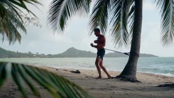 Atletico Uomo Caucasico Pantaloncini Treni Scioperi Una Spiaggia Sabbia Sotto — Video Stock