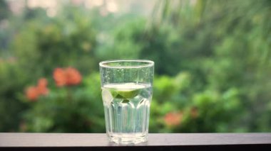 Su ve limon dilimli cam tutan adam. 