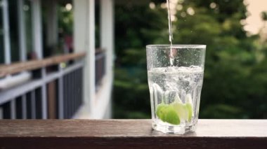 Su ve limon dilimli cam tutan adam. 