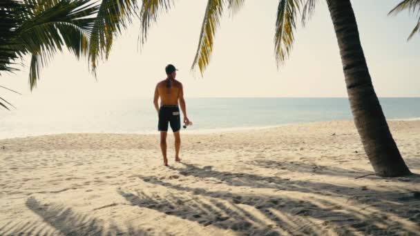 Lekkoatletyczny Biały Mężczyzna Spodenkach Pociągi Uderza Piaszczystej Plaży Pod Palmami — Wideo stockowe