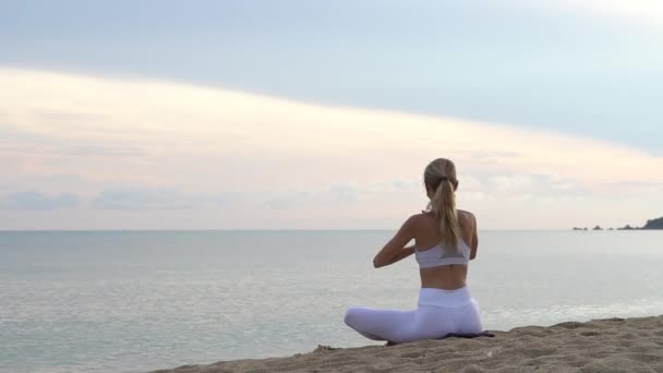 Ung Kvinna Yoga Sittande Sand Havet Kust Färgglada Solnedgången — Stockvideo