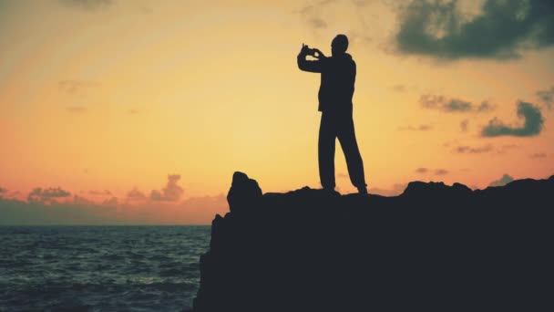 Silhouette Eines Mannes Der Bei Sonnenaufgang Auf Den Felsen Meer — Stockvideo