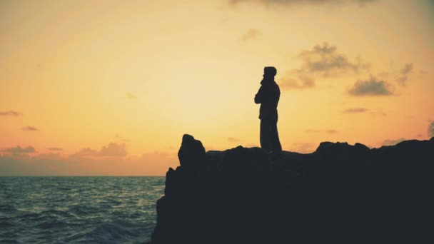 Sylwetka Mężczyzny Stojącego Skałach Nad Morzem Wschodzie Słońca — Wideo stockowe