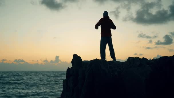 Sylwetka Mężczyzny Stojącego Skałach Nad Morzem Wschodzie Słońca — Wideo stockowe