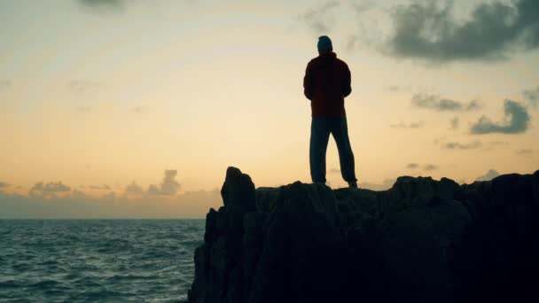 Silhuett Man Som Står Klipporna Vid Havet Vid Soluppgången — Stockvideo