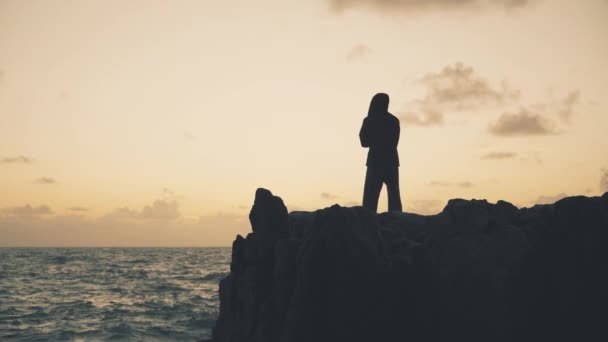 Silhouette Eines Mannes Der Bei Sonnenaufgang Auf Den Felsen Meer — Stockvideo