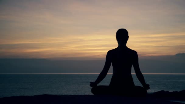 Silhouette Meditating Young Woman Sitting Lotus Position Rock Sea Background — Stock Video