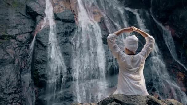 Young Adult Woman White Clothes Sits Rock Background Waterfall Practices — Stock Video