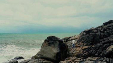 Genç çekici adam sahilde yürüyor. 