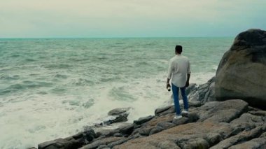 Yavaş çekim videosu. Sahilde duran bir adam var.