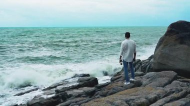 Yavaş çekim videosu. Sahilde duran bir adam var.