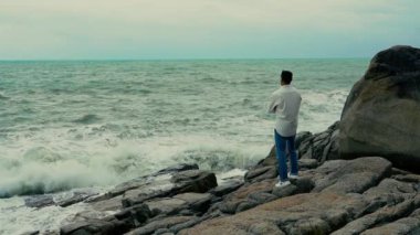 Yavaş çekim videosu. Sahilde duran bir adam var.