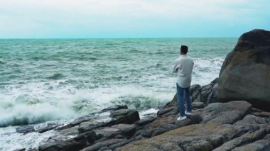 Yavaş çekim videosu. Sahilde duran bir adam var.