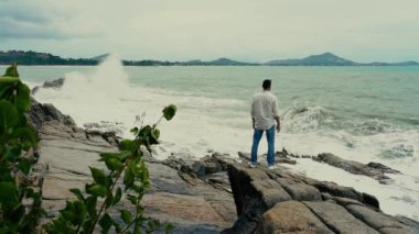 Yavaş çekim videosu. Sahilde duran bir adam var.