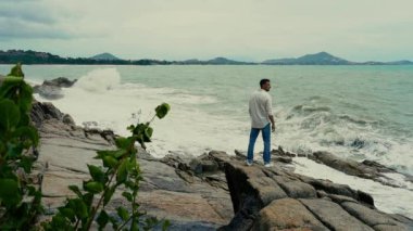 Yavaş çekim videosu. Sahilde duran bir adam var.