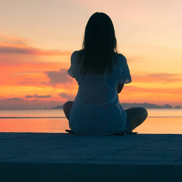 Genç Bir Kadın Sette Oturur Denizin Üzerinde Günbatımının Tadını Çıkarır — Stok fotoğraf