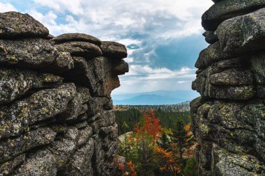 Vadinin panoramasındaki kayaların arasına bak. Sonbahar ağaçları ve tepeleri olan dağ sıraları.