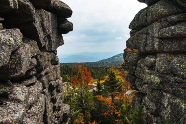 Vadinin panoramasındaki kayaların arasına bak. Sonbahar ağaçları ve tepeleri olan dağ sıraları.