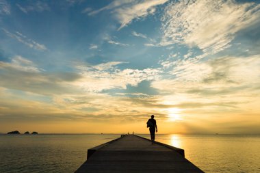 İskelede günbatımında tropik bir adada yürüyen kadın. Koh Samui, Tayland