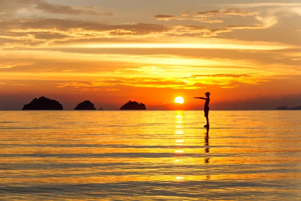 Silhouette of a man standing in the sea at sunset islands background on a tropical island