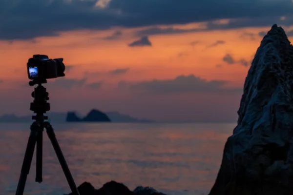 La cámara de pie en la playa de una isla tropical y fotografiado puesta de sol — Foto de Stock