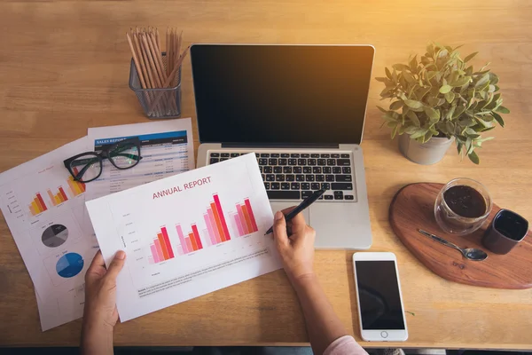 Bovenaanzicht van de jonge werkende vrouw met laptop en verslag lezen — Stockfoto