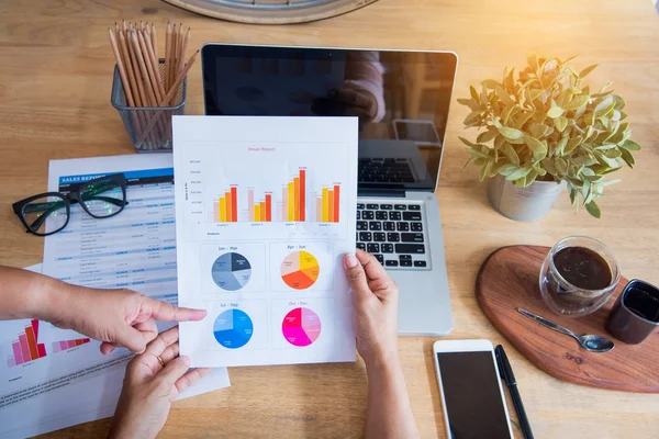 Bovenaanzicht van de jonge werkende vrouw met laptop en jaarverslag lezen — Stockfoto