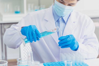 Bilim adamı covid-19 virüs kimya araştırması biyoteknoloji antikor örneği laboratuvarı virüse karşı aşı üretiyor. Bilim adamı mikroskoba bakıyor, bilim test tüpü kimya laboratuvarını analiz ediyor.