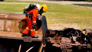 İtfaiyeci yangın hortumuyla, kimyasal köpüklü sprey motorla savaşıyor. İtfaiyeciler korunmak için kasketli, vücut korumalı üniformalı üniforma giyer. Yangın söndürücüde kurtarma eğitimi.