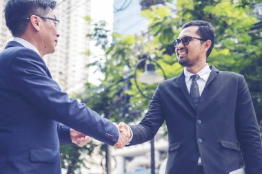 Takım İş Ortakları yeni projeyi başlatmak için el sıkışıyor. Ofis dışı modern şehir geçmişi dışında el sıkışan takım çalışması ortaklığı. İş adamı el sıkışması. İş konsepti