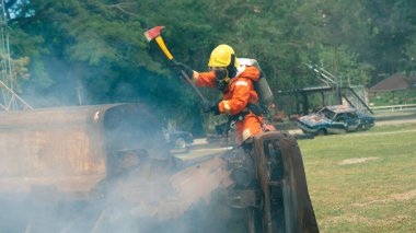 İtfaiyeci yangın hortumuyla, kimyasal köpüklü sprey motorla savaşıyor. İtfaiyeciler korunmak için kasketli, vücut korumalı üniformalı üniforma giyer. Yangın söndürücüde kurtarma eğitimi.