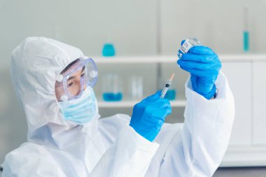 Bilim adamı covid-19 virüs kimya araştırması biyoteknoloji antikor örneği laboratuvarı virüse karşı aşı üretiyor. Bilim adamı mikroskoba bakıyor, bilim test tüpü kimya laboratuvarını analiz ediyor.