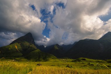 Güneşli bir günde güzel bir manzara, yeşil çayır, beyaz bulut, mavi gökyüzü. Görkemli yeşil manzara büyük dağ tepesi bulutlu vadi manzarası kırsal yeşil çayır manzarası