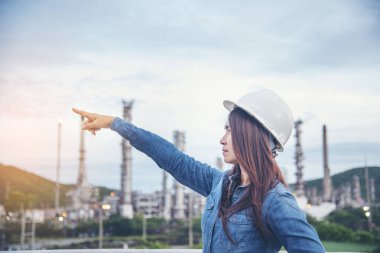 Kadın mühendis, inşaat işçisi. Rafineri petrol fabrikasında çalışan kadın mühendis. Genç inşaat mühendisi, başlık kaskı inşaat alanında takıyor..
