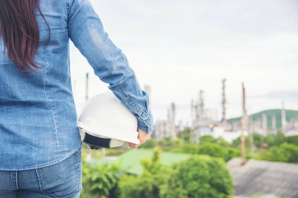 Woman engineer entrepreneur construction industry worker. Female engineer working refinery oil plant manufacturing. Young civil engineering construction wear hard hat safety helmet construction site.