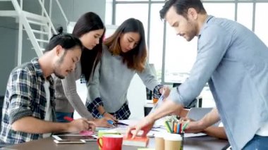 Çeşitli etnik gruplardan oluşan bir grup iş adamı konferans odasında toplantı yapıyor. İş grafiği, grafik ve veri bilgileriyle beyin fırtınası yapıyorlar. Takım çalışması iş birliği yapar. Güven ortakları bir araya gelir.