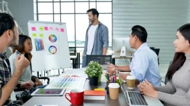 Çeşitli etnik gruplardan oluşan bir grup iş adamı konferans odasında toplantı yapıyor. İş grafiği, grafik ve veri bilgileriyle beyin fırtınası yapıyorlar. Takım çalışması iş birliği yapar. Güven ortakları bir araya gelir.