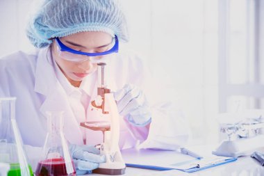 Kadın bilim adamı mikroskopa bakar, bilim test tüpü laboratuvar araştırma deneylerindeki bilimsel örnekleri analiz eder ve biyoteknoloji virüse karşı aşı üretir. Kimya bilimi laboratuarı kavramı