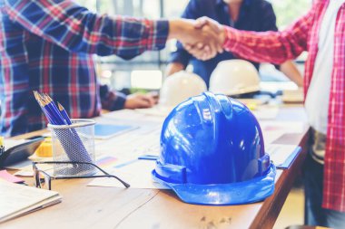 İnşaat mühendisi takım çalışması güvenlik ekibi, inşaat sahasında beyaz sarı şapkalı güvenlik ekipmanı tutuyor. Hardhat İnşaat Mühendisliği Mühendisliği Yöneticisini Koru