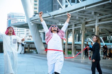 İslami işadamı, modern Müslüman BAE şehrinde başarılı iş anlaşmaları için el sıkışıyor. Arap adam tesettürlü Müslüman elbisesi giyiyor. Çok kültürlü iş adamları, konuşan grup şehirleriyle tanışıyor.