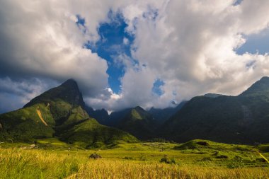 Güneşli bir günde güzel bir manzara, yeşil çayır, beyaz bulut, mavi gökyüzü. Görkemli yeşil manzara büyük dağ tepesi bulutlu vadi manzarası kırsal yeşil çayır manzarası