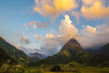 Güneşli bir günde güzel bir manzara, yeşil çayır, beyaz bulut, mavi gökyüzü. Görkemli yeşil manzara büyük dağ tepesi bulutlu vadi manzarası kırsal yeşil çayır manzarası